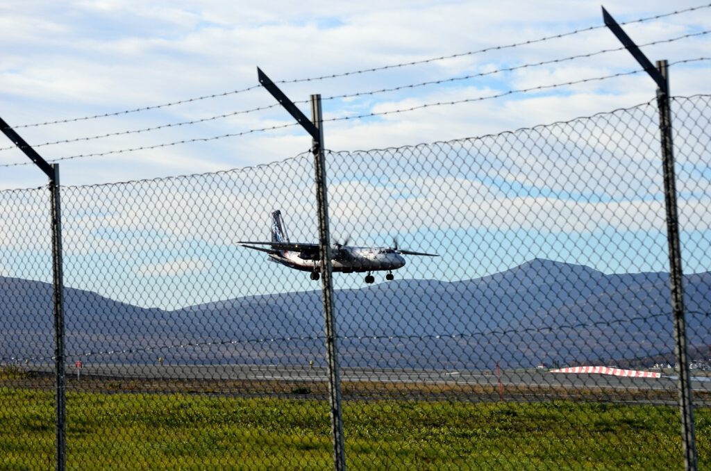 chain link fence with airplane landing